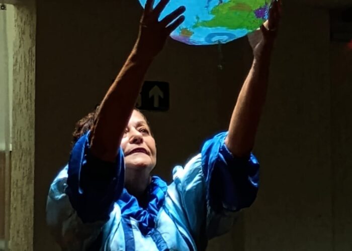 Mulher branca, vestido azul, segurando ao alto um globo terrestre